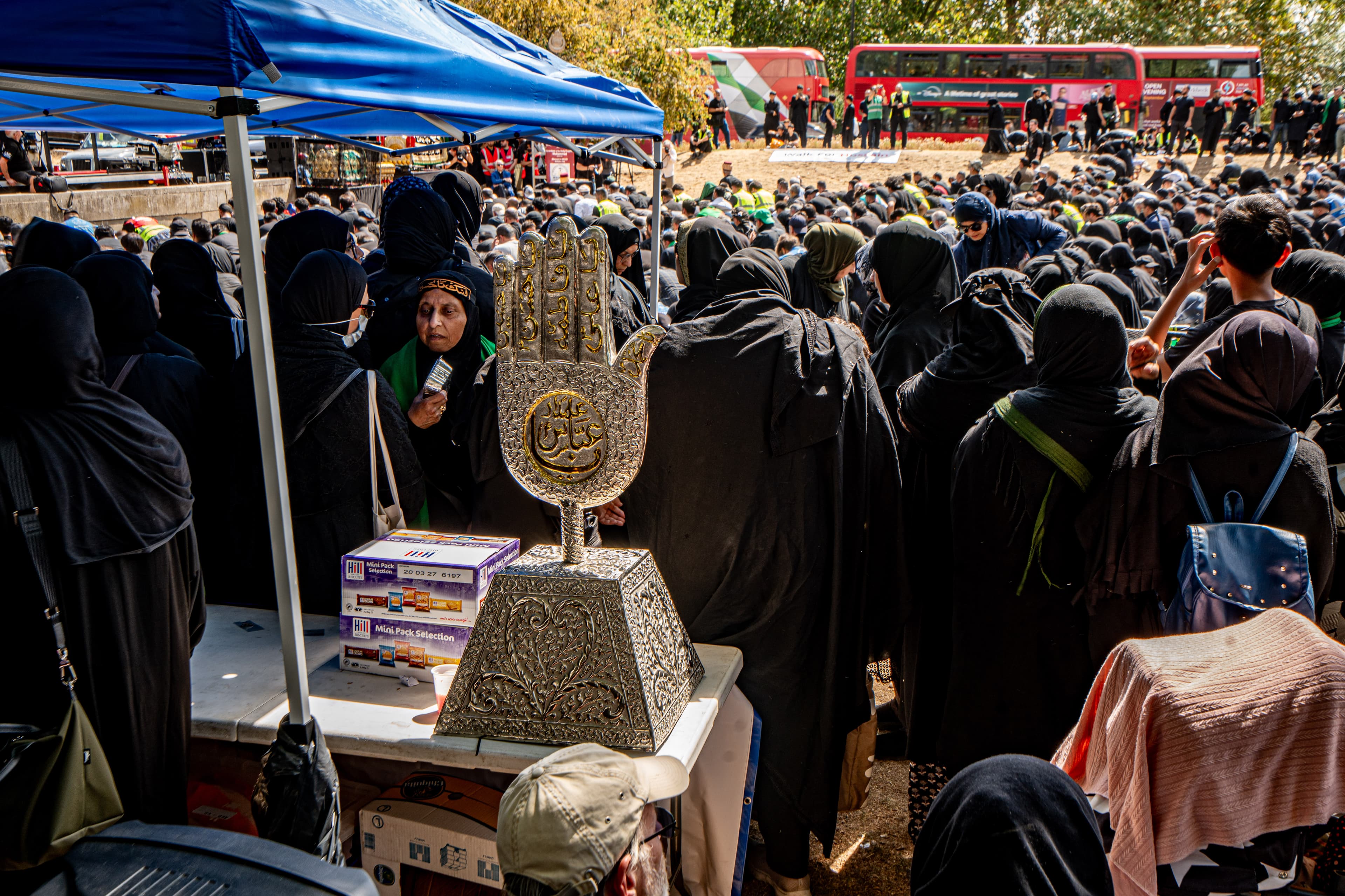 A busy Arbaeen gathering with the ceremonial alam in view.